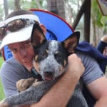 Man hugging dog — Caravan Park in Kinka Beach, QLD