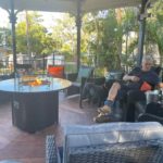 Man & Labrador Sitting Near Fire Pit — Caravan Park in Kinka Beach, QLD